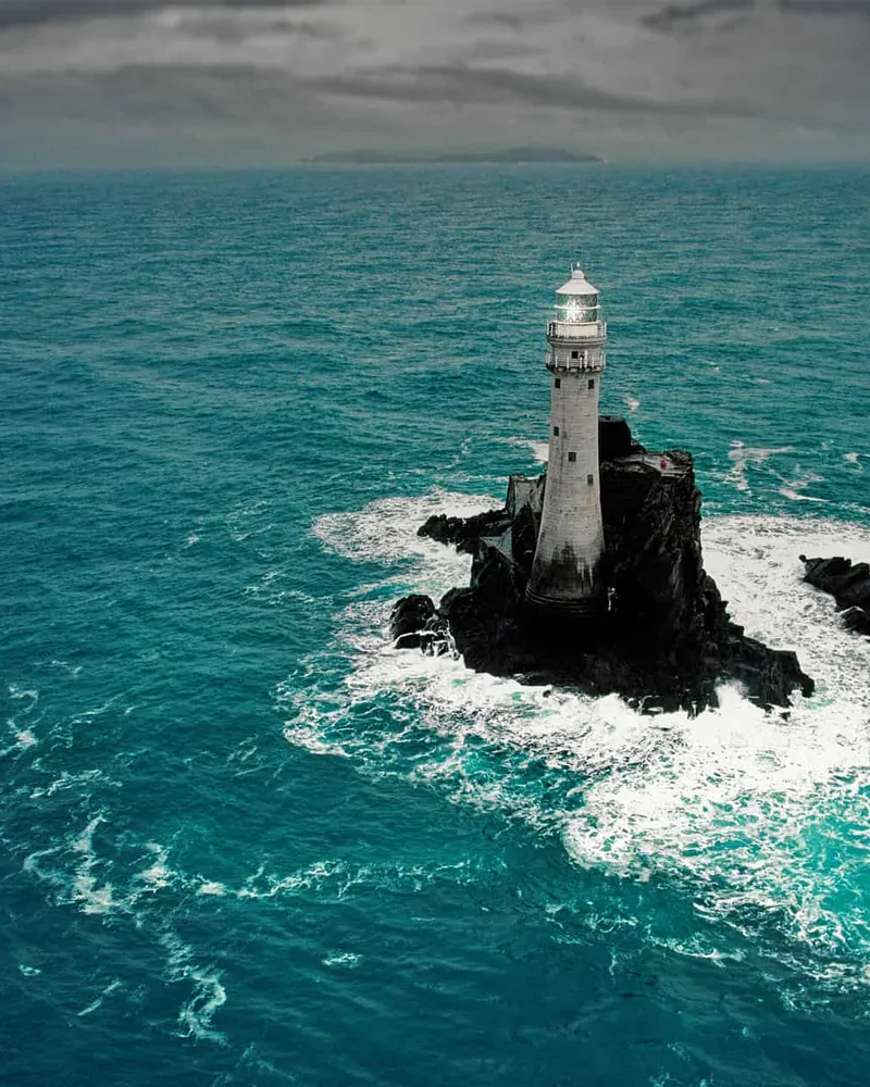Lighthouse standing on a rock in open sea