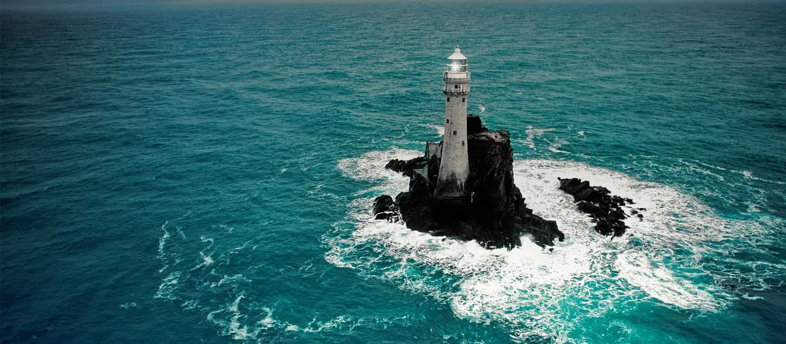Lighthouse standing on a rock in open sea