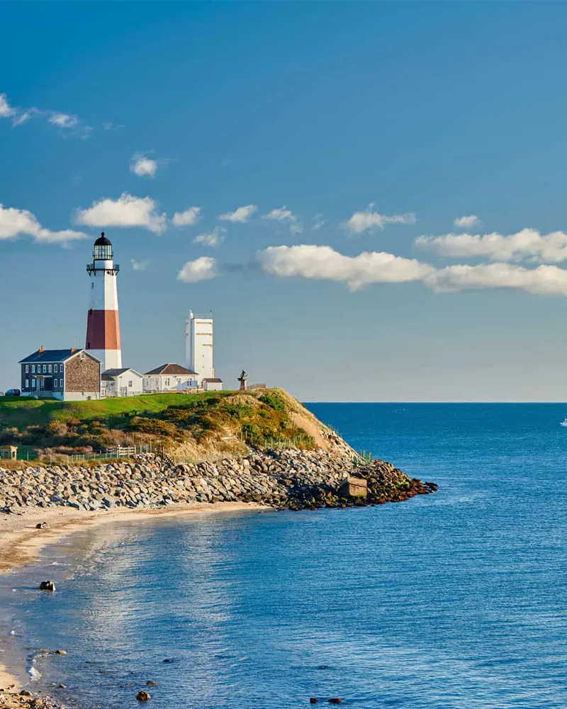 Lighthouse on a bluff beside a beach on a clear day