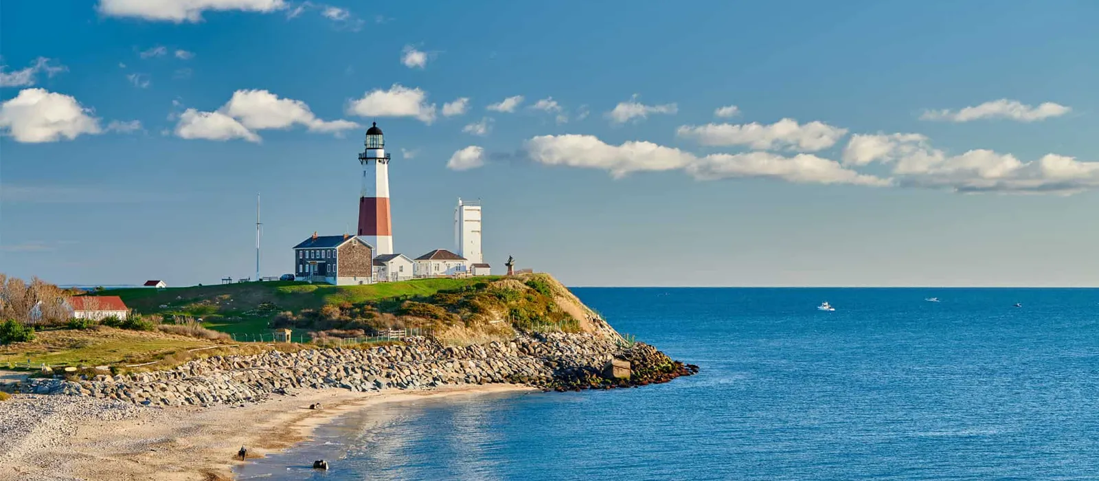 Lighthouse on a bluff beside a beach on a clear day