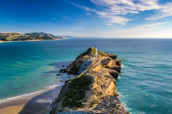 Lighthouse on a narrow headland reaching into the sea