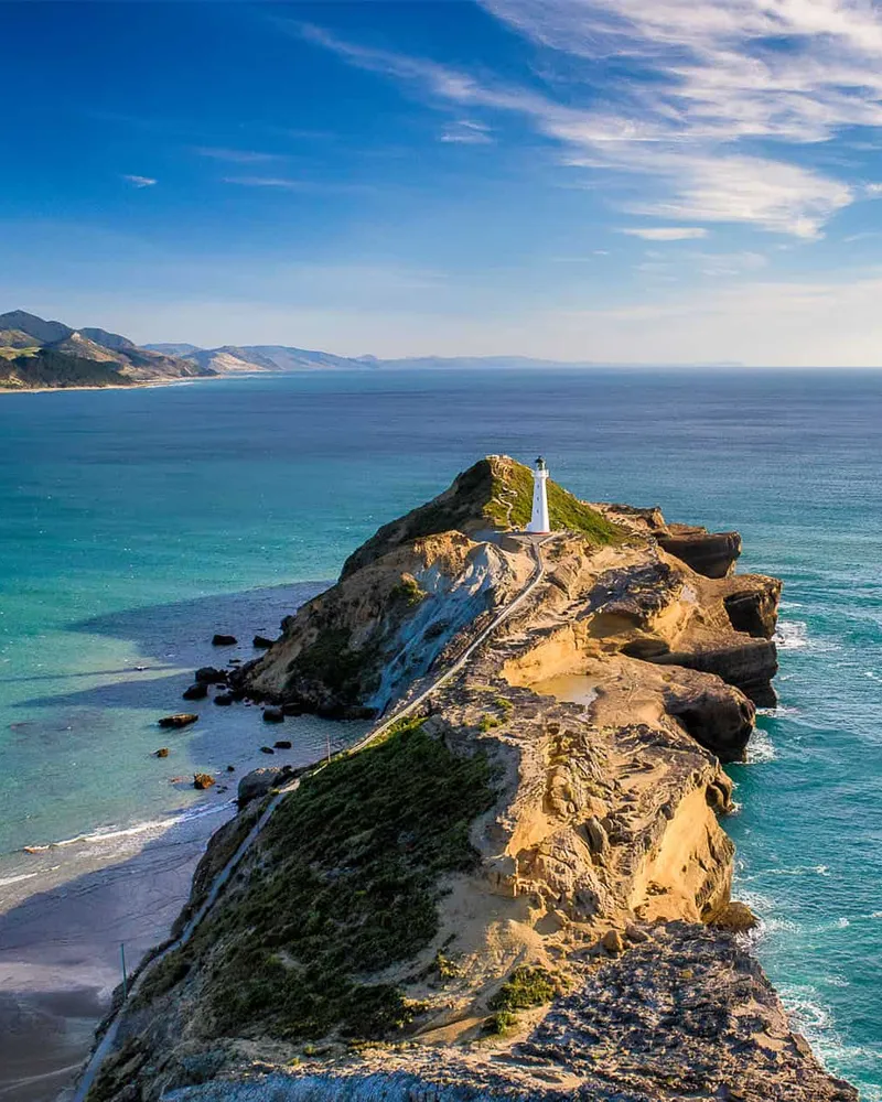 Lighthouse on a narrow headland reaching into the sea