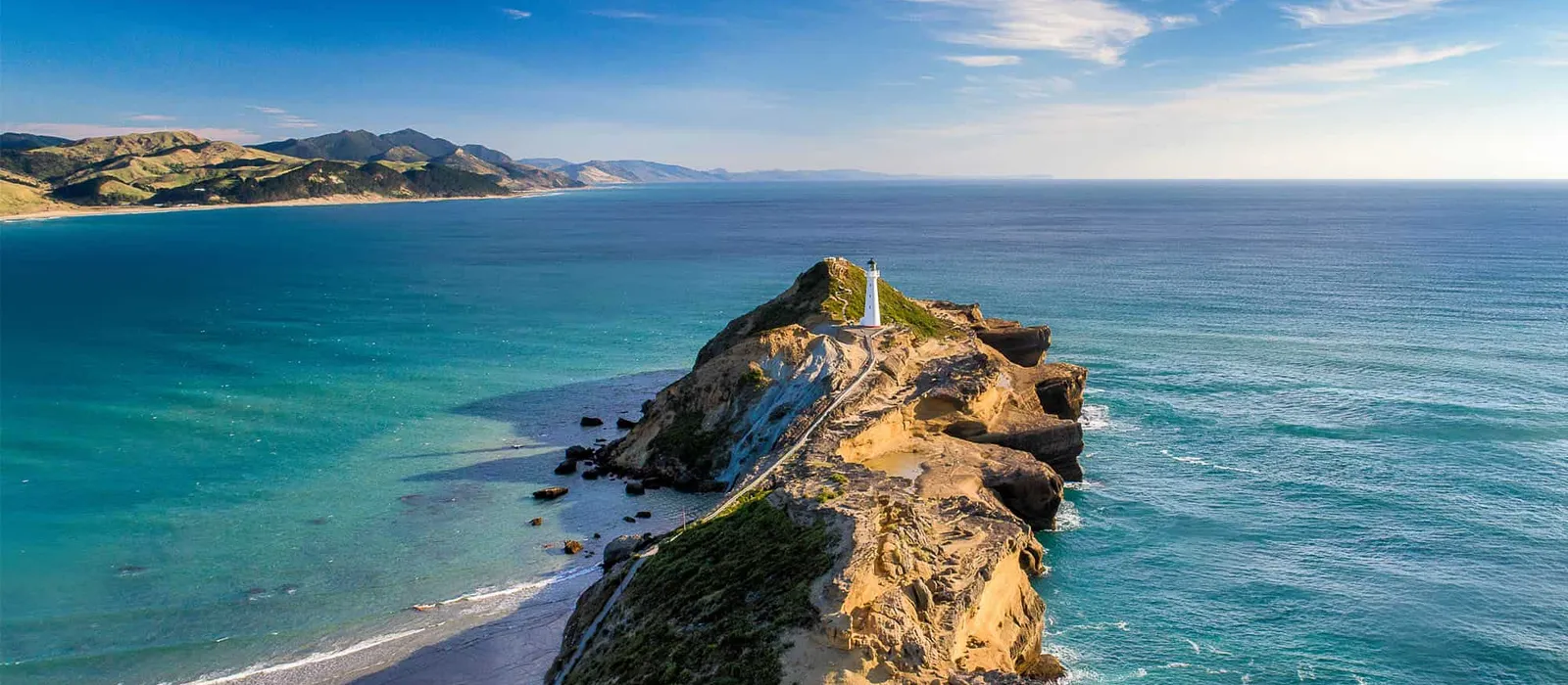 Lighthouse on a narrow headland reaching into the sea