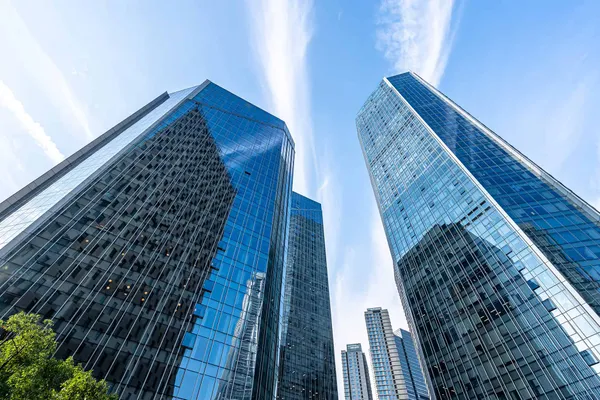 Glass office towers against a blue sky