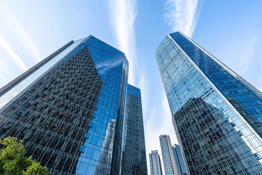 Glass office towers against a blue sky